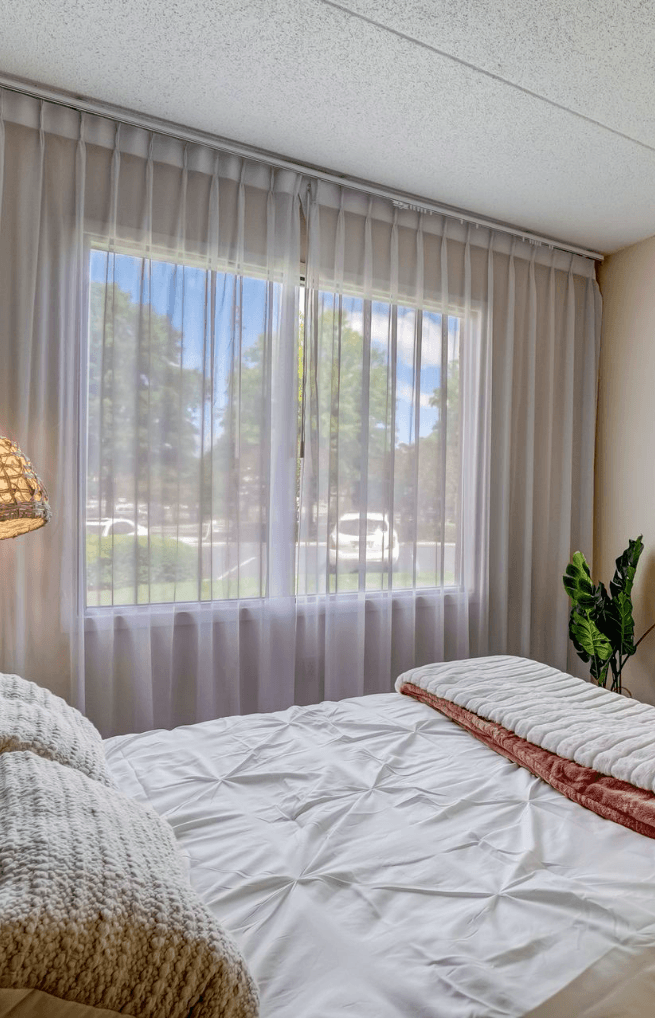 apartment bedroom with white bed and colorful pillows